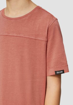 Lichtroze T-shirt met korte mouwen van zachte katoen, met een ronde hals en topstiknaadaccenten. Heeft een zwarte "SLVR" label op de mouw.