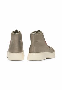 Høje sneakers i lys grå tekstil med en glat finish, featuring en hvid sål og rød accent på siden. Lynlås på bagsiden.