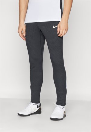 Black, ribbed athletic pants with a fitted design. Features a small white Nike logo on the thigh and a zipper pocket on the side.