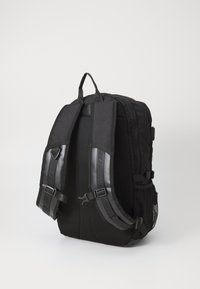 Črn nahrbtnik z oblazinjeno mrežasto hrbtno stranjo in nastavljivimi naramnicami. Vsebuje sponke in teksturirane detajle. Minimalističen dizajn z elegantnim profilom.