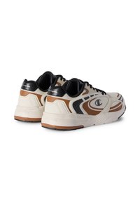 Sneaker mit einem Obermaterial aus cremefarbenem Mesh, schwarzen Akzenten und braunen Details. Verfügt über eine strukturierte Überlagerung, eine gepolsterte Sohle und schwarze Schnürsenkel.