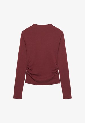 Pitkähihainen viininpunainen paita, jossa on sivusaumoissa kerätty yksityiskohta, pyöreä pääntie ja pehmeä kangaspinta. Yksinkertainen muotoilu, ilman kuvioita tai koristeita.