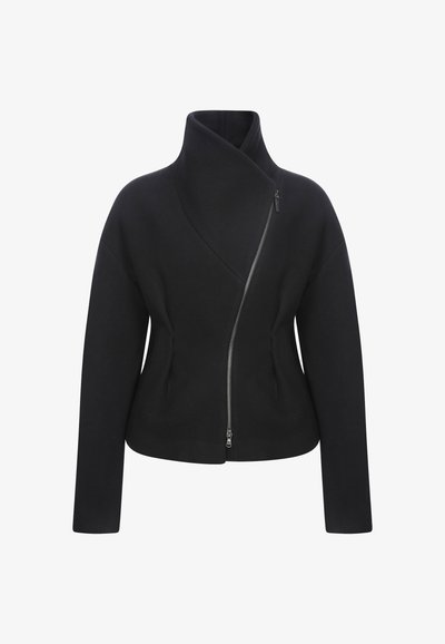 Musta, kokkuvolditud pintsak kõrge kaelusega, asümmeetrilise tõmbluku kinnitusega, pikkade varrukatega ja siledast tekstuurist. Selged jooned, ilma nähtavate mustriteta.