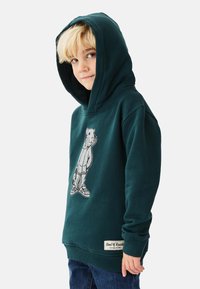 Mörkgrön hoodie med björnmotiv, tillverkad av bomull, stor huva, ribbade muddar och en vävd etikett vid fållen.