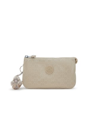 Beige taske med lynlås lavet af tekstureret materiale, med et geometrisk mønster, et logo emblem og en blød dekorativ charme på en kæde.