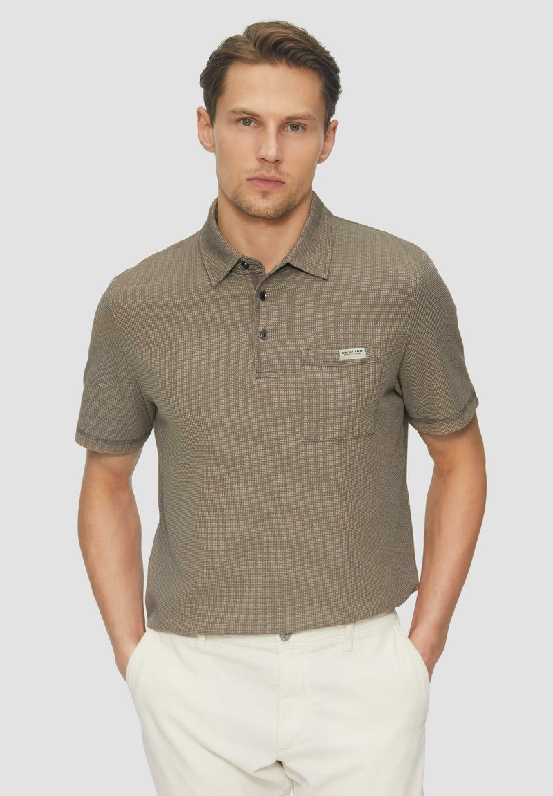 Kurzärmliges Poloshirt aus strukturiertem braunem Stoff mit Kragen, drei Knöpfen, einer Brusttasche und einem kleinen Etikett auf der Tasche.