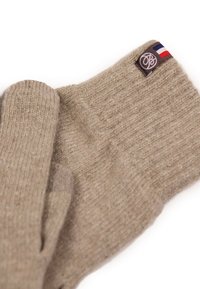 Gants en tricot beige avec texture côtelée, présentant un patch logo tissé et un petit accent tricolore. Matériau doux et chaud.