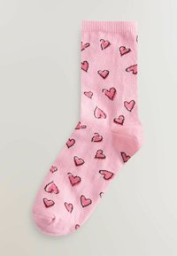 Șosetă roz din bumbac, cu un model de inimioare mici în nuanțe variate de roz, conturate cu negru. Lungime standard până la gambă.