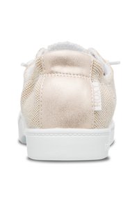 Lys beige sneaker med en teksturert mesh-overdel, metallisk detalj på hælen, og en hvit gummisåle. Har snøringer og et lite logo-merke.