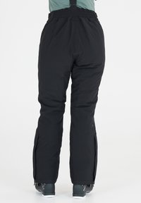 Zwarte geïsoleerde sneeuwbroeken met verstelbare schouderbanden, elastische tailleband en geventileerde ritsen aan de zijkant; ontworpen voor comfort in koude omstandigheden.