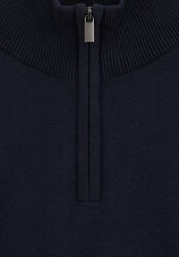 Tumši zils džemperis ar rāvējslēdzēju kakla izgriezumā, izgatavots no mīksta trikotāžas materiāla, ar ribotu faktūru un sudraba rāvējslēdzēja dekoru kakla izgriezumā.