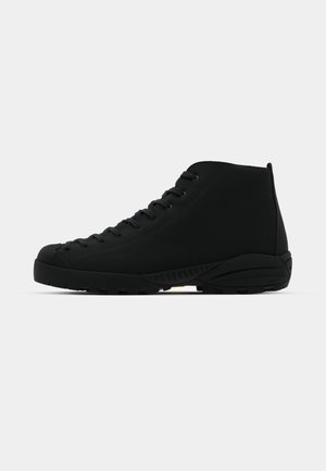 Bottines noires en tissu texturé. Dotées d'un système de laçage, d'une semelle en caoutchouc et de détails latéraux pour une meilleure adhérence.