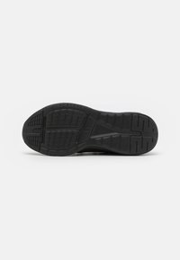 Sole di scarpa sportiva nera con motivo di presa testurizzato e design del battistrada distintivo. Presenta una sezione del tallone liscia e flessibile per il comfort.