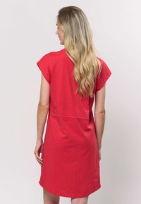 Rochie roșie cu mâneci scurte, croială lejeră, cu cusătură în talie și tiv rotunjit. Confecționată din material moale și ușor.