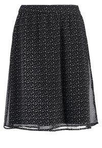 Schwarze Bluse mit weißem Punktmuster, elastischem Bund, fließendem Design und durchsichtigen Panel-Akzenten an den Seiten. Leichte Stoffqualität.
