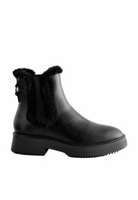 Botas de tobillo de cuero negro con un forro y ribete de piel sintética, que presentan una suela texturizada y un detalle de hebilla lateral para un estilo adicional.