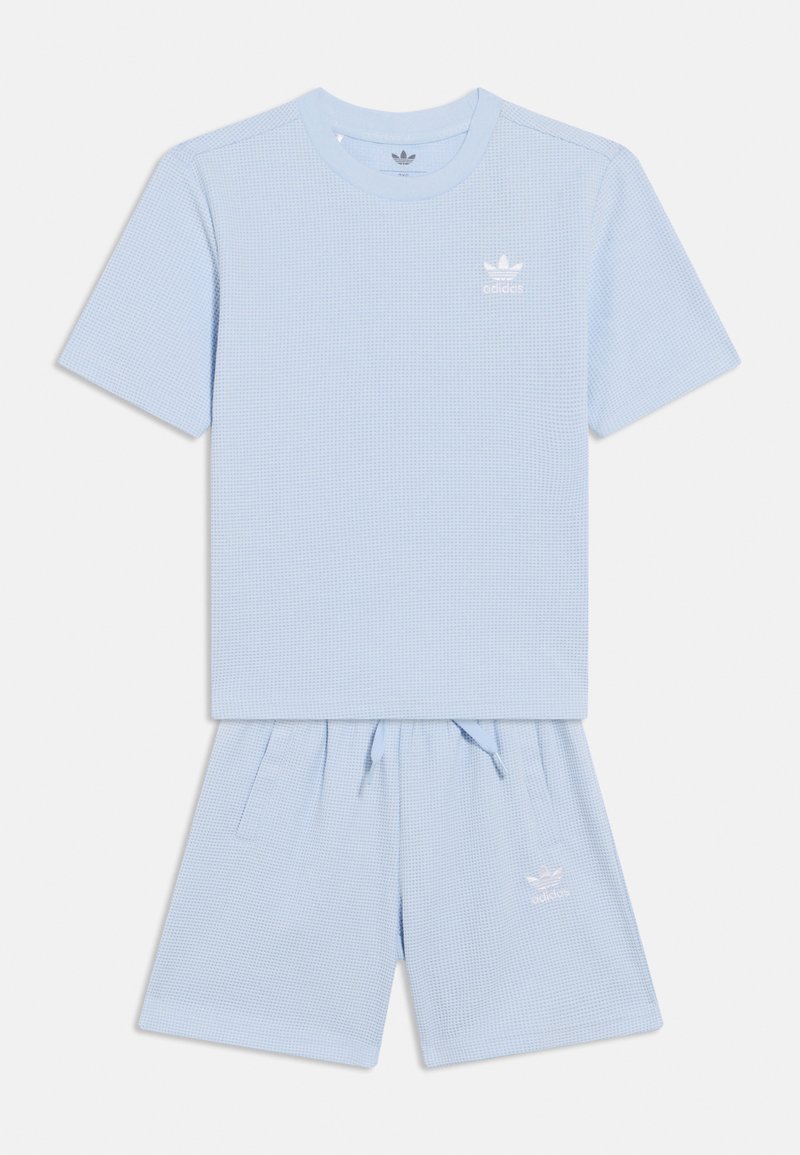 Σετ πουκάμισο με κοντά μανίκια και σορτς σε ανοιχτό μπλε χρώμα με υφασμένο μοτίβο. Διαθέτει στρογγυλή λαιμόκοψη και ζώνη μέσης με κορδόνι, με λογότυπο εμπορικού σήματος και στα δύο.