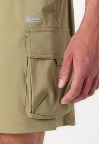 Khaki shorts met een gestructureerde afwerking, voorzien van een grote zijzak en een Quiksilver-logo. Korte zoom en gestroomlijnd ontwerp.