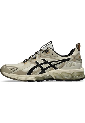 Zapatilla deportiva beige y negra con parte superior de malla, suela de goma, amortiguación de gel y acentos de logo distintivos. Diseño de corte bajo con un sistema de laceado seguro.
