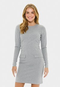 Grey long-sleeve dress made of soft fabric, featuring a fitted silhouette, two front pockets, and a round neckline.
