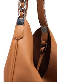 Sac à main en simili cuir marron clair avec une texture lisse, doté d'une bandoulière chaîne argentée épaisse et de poches intérieures plaquées. Design arrondi et minimaliste.