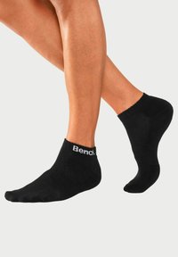 Schwarze Knöchelsocken mit gerippter Textur, die ein weißes "Bench."-Logo am Bündchen tragen und so konzipiert sind, dass sie eng um den Knöchel sitzen.