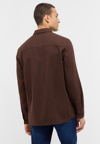 Dunkelbraunes Langarmhemd mit geradem Kragen, mit Knöpfen an den Ärmeln und einer glatten Textur, von hinten gezeigt.
