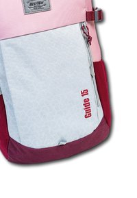 Roze en grijze rugzak met een geometrisch patroon, voorzien van een rode "Guide 15" label in de linker benedenhoek en gemaakt van duurzaam stoffen materiaal.
