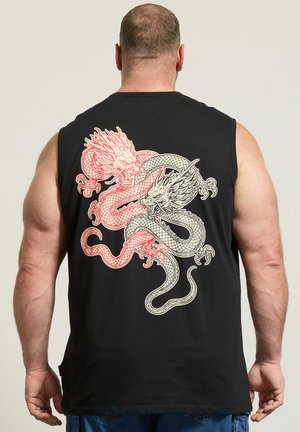 muskularny mężczyzna w czarnej koszulce bez rękawów z dużym czerwono-białym wzorem splecionego smoka na plecach, stojący na prostym tle.