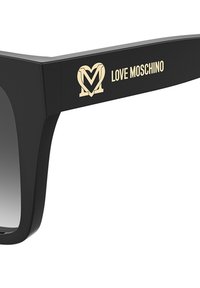 Black sunglasses with a bold geometric design, featuring a gold "Love Moschino" logo on the temple and gradient lenses.