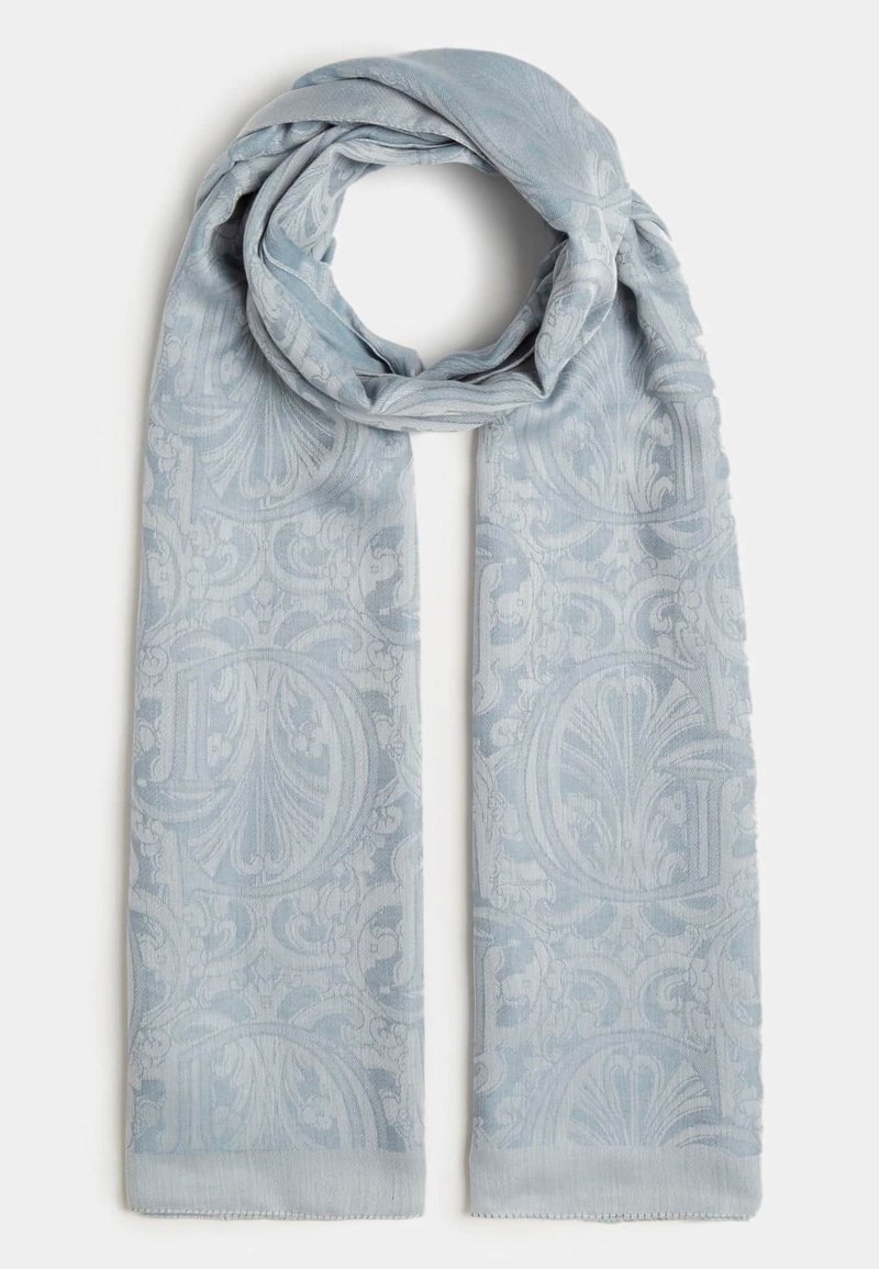 Écharpe bleu clair avec motifs floraux et ornementaux jacquard subtils, repliée en boucle lâche sur un fond blanc.