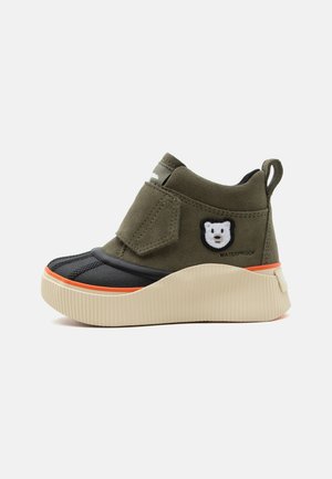Barnes vandtætte ankelstøvle med olivengrønt stof, sort tå, beige sål, orange kant og hvid bjørnepatch på siden.