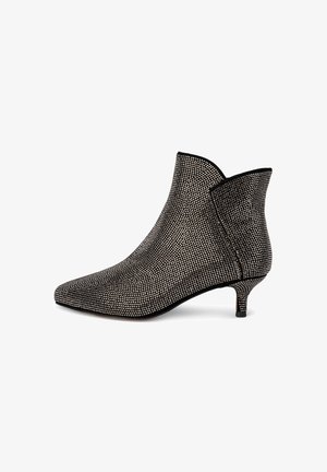 Bottine à bout pointu, recouverte de strass noirs et argentés, avec un petit talon et un design élégant et structuré.