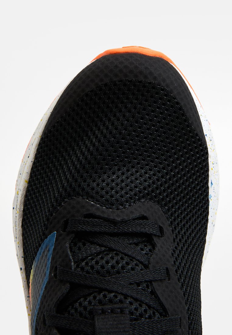Baskets de sport noires en mesh avec une tige texturée, dotées d'un accent bleu et d'une semelle multicolore à motifs. Lacets bien maintenus.