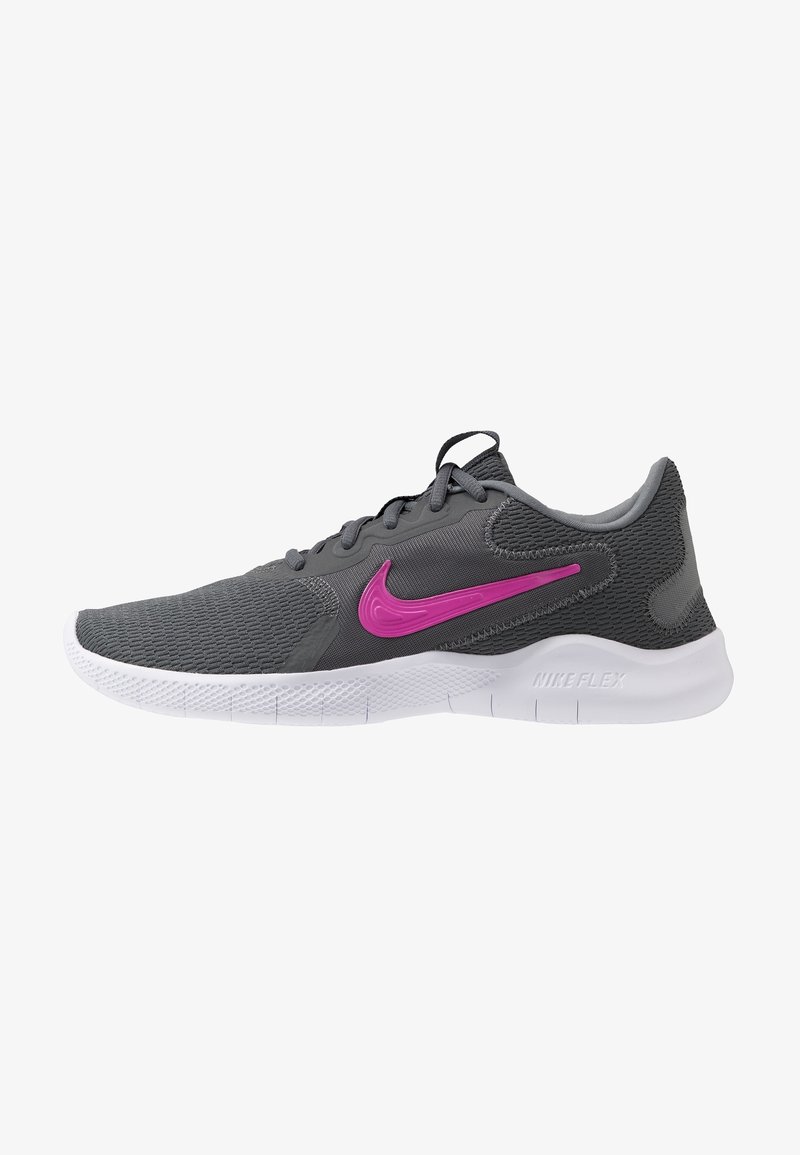 Chaussure de sport en mesh gris foncé avec semelle blanche et logo Nike swoosh rose sur le côté, lacée avec des lacets noirs.