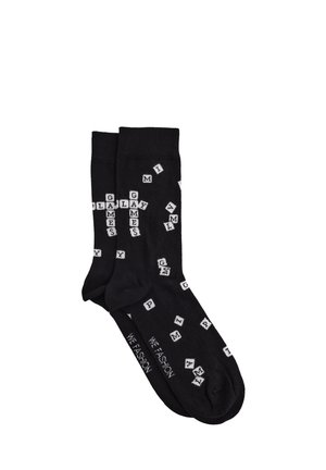 Čierne členkové ponožky s bielymi tlačenými písmenami zobrazujúcimi herné dlaždice. Mäkká pletená látka, rebrový lem. Text na podrážkach znie "#WE FASHION."