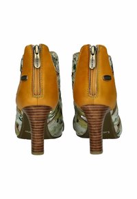 Botas de tobillo de cuero marrón con paneles laterales de patrón floral y cremallera trasera; tacón de estilo madera; diseño abierto.