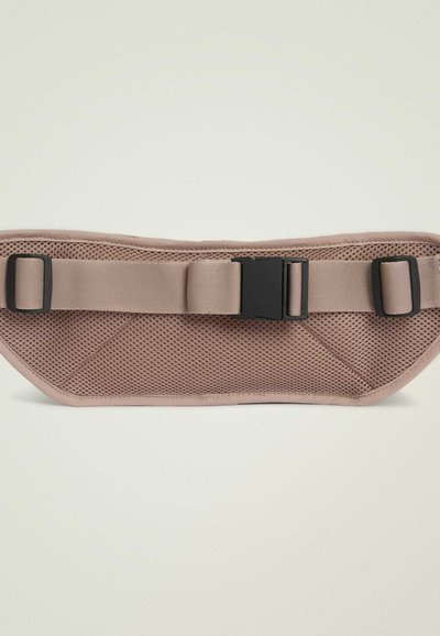 Dog harness in light beige with breathable mesh design. Features a wide strap, adjustable buckle, and reinforced stitching for durability.