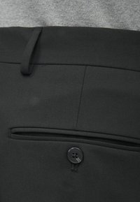 Melnas auduma bikses ar gludu apdari, kas aprīkotas ar vienu pogu un diskrētu sānu kabatu. Ikdienas, piegriezta dizaina.