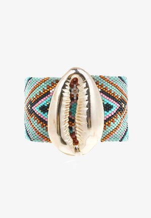 Bracelet manchette en perles présentant des perles multicolores disposées en motifs de bleu sarcelle, rose et orange. Au centre, un grand accent en coquillage cauri argenté.