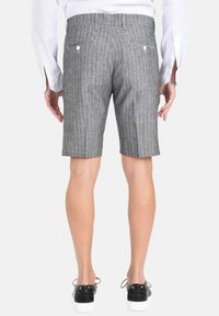 Pantaloni corti grigi a righe realizzati in tessuto leggero, caratterizzati da una linea dritta, due tasche posteriori con bottoni e una lunghezza a metà coscia.