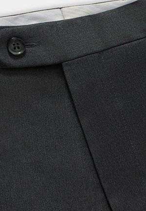 Pantaloni neri su misura con tessuto morbido, dettaglio del bottone in vita e design plissettato per una forma strutturata.