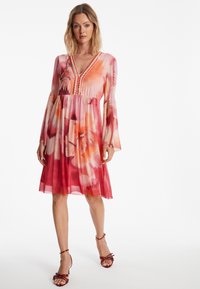 Blumenmusterkleid in Pink- und Orangetönen, mit V-Ausschnitt, langen Glockenärmeln und dezent gerafftem Bund.