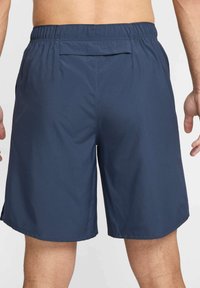 Pantalones cortos azul marino hechos de material ligero, con una cintura elástica y bolsillos laterales, con una textura suave y un diseño limpio.