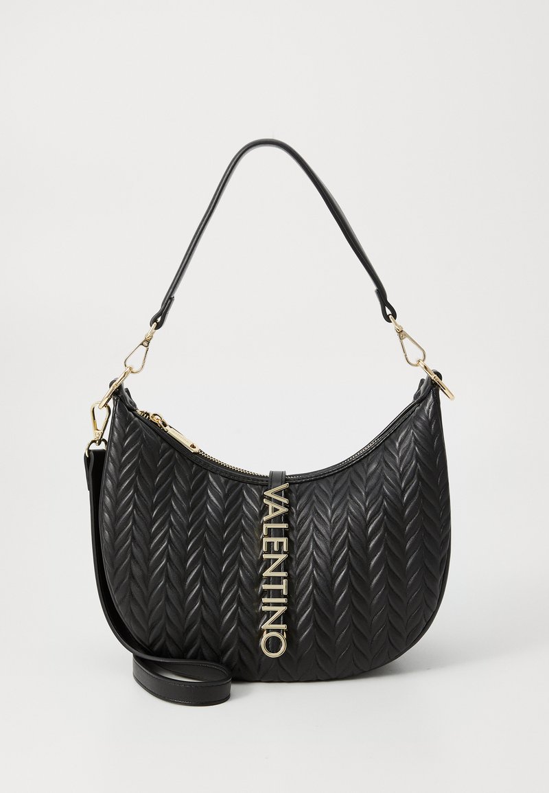 Bolsa de couro preta com padrão pespontado em espinha de peixe, hardware dourado e um detalhe de corrente. Apresenta um fecho superior e uma alça ajustável.