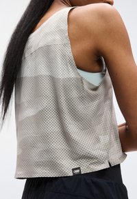 Ανοιχτό γκρι αμάνικη μπλούζα με υφασμάτινο καρω σχέδιο, διαθέτει άνετη εφαρμογή, στρογγυλεμένη βάση και μικρό μαύρο λογότυπο στο κάτω μέρος.