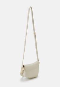 Crossbody-väska i ljusbeige konstläder, böjd form, justerbar rem, guldfärgad detaljer, slät yta, minimalistisk design.