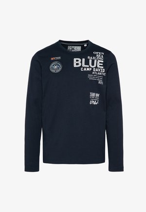 Camiseta de manga larga de color azul marino de algodón con cuello redondo. Presenta gráficos impresos, parches y acentos de texto en blanco. Espalda lisa.