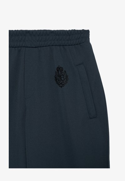 Dunkelblaue Sporthosen aus einem strukturierten Stoff, mit einem elastischen Bund, seitlichen Taschen und einem schwarzen gestickten Logo.