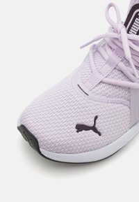 Šviesiai violetinės kedai su tekstūruotu tinkleliu viršuje, plokščiais raišteliais, guminėmis padais ir kontrastingu tamsiai violetiniu Puma logotipu šone.